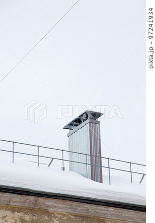 Smoke, rectangular, metal exhaust pipe on the roof of a modern house. 97241934