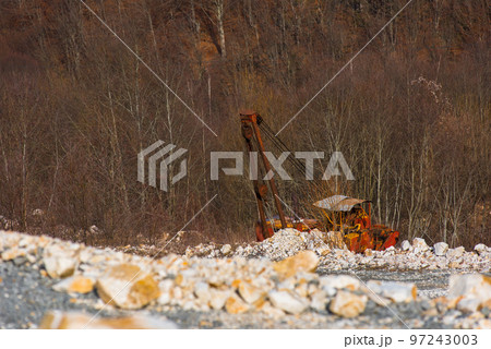 Old broken abandoned rusty excavator in a quarry 97243003