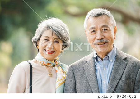 屋外でほほえむ上品なシニア夫婦 97244032