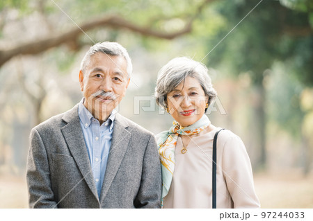 屋外でほほえむ上品なシニア夫婦 97244033