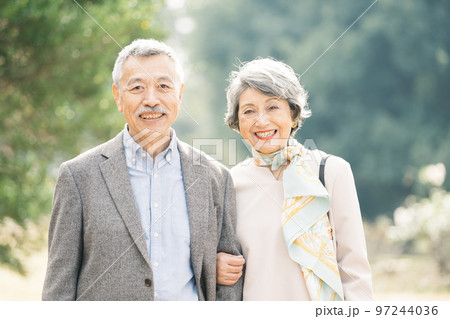 屋外でほほえむ上品なシニア夫婦 97244036