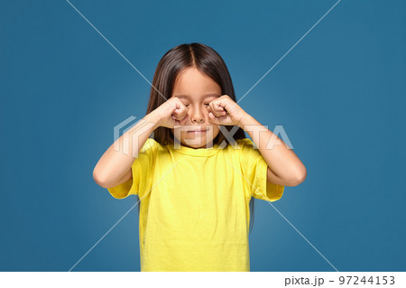 Sad offended little girl cries in yellow t-shirt 97244153