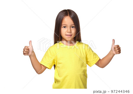 Girl in yellow t-shirt shows her hands with thumbs Girl in yellow t-shirt shows her hands with thumbs 97244346