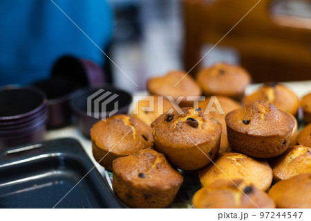 Cupcakes with raisins just from oven, taking off from cupcakes cutters. Selective focus. Cupcakes with raisins just from oven, taking off from cupcakes cutters. Selective focus. 97244547