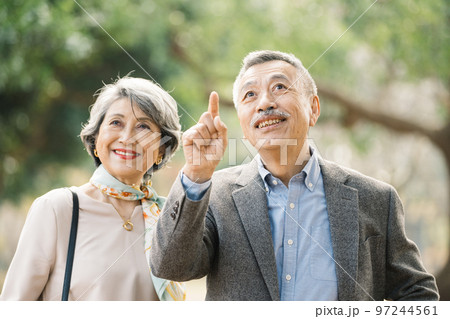 屋外でほほえむ上品なシニア夫婦 97244561