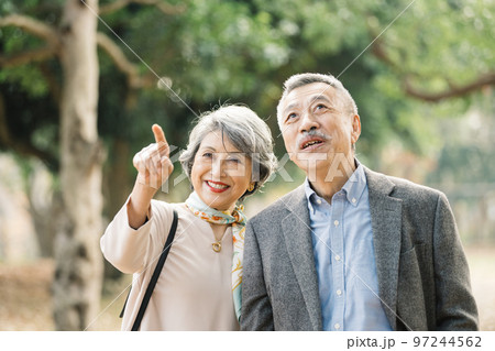 屋外でほほえむ上品なシニア夫婦 97244562