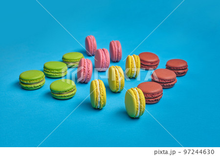 Colored macaron or macaroon, sweet meringue-based confection on blue background. Close-up, copy space. 97244630