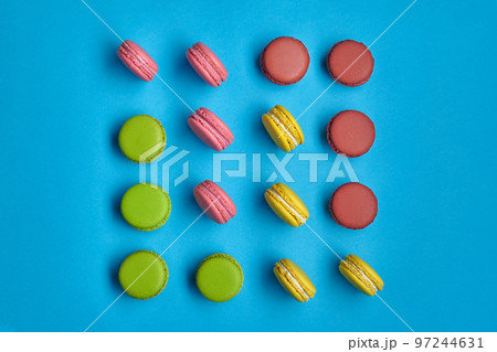 Colored macaron or macaroon, sweet meringue-based confection on blue background. Close-up, copy space. 97244631