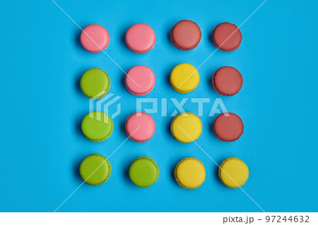 Colored macaron or macaroon, sweet meringue-based confection on blue background. Close-up, copy space. 97244632