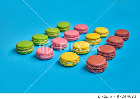 Colored macaron or macaroon, sweet meringue-based confection on blue background. Close-up, copy space. 97244633