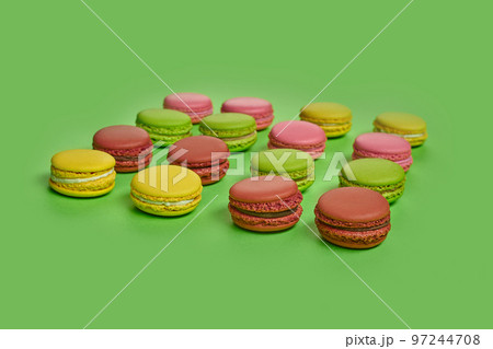 Colored macaron or macaroon, sweet meringue-based confection on green background. Close-up, copy space. 97244708