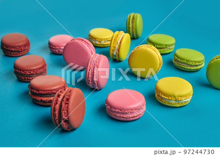 Colored macaron or macaroon, sweet meringue-based confection on blue background. Close-up, copy space. 97244730