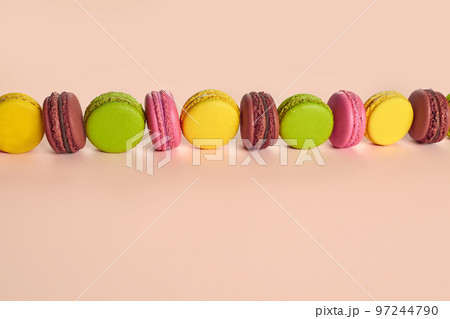 Colored macaron or macaroon, sweet meringue-based confection on pink background. Close-up, copy space. Colored macaron or macaroon, sweet meringue-based confection on pink background. Close-up, copy space. 97244790