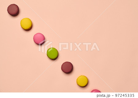 Colored macaron or macaroon, sweet meringue-based confection on pink background. Close-up, copy space. Colored macaron or macaroon, sweet meringue-based confection on pink background. Close-up, copy space. 97245335