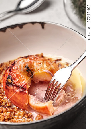 Close-up photo of a tasty baked apple stuffed with honey and nuts. Close-up photo of a tasty baked apple stuffed with honey and nuts. 97245409