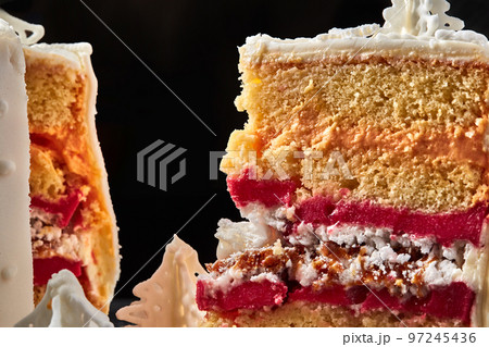 Delicious pink cream cake against a black studio background. Delicious pink cream cake against a black studio background. 97245436