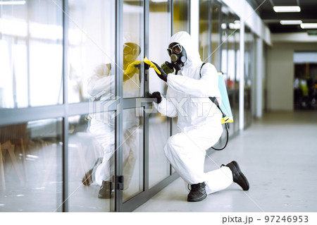 Cleaning and disinfection of office to prevent COVID-19, Man in protective hazmat suit washes office 97246953