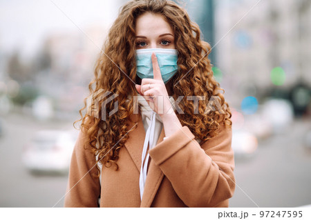 Woman in protective medical mask on her face on the street. Woman, wear face mask. Corona virus. Woman in protective medical mask on her face on the street. Woman, wear face mask. Corona virus. 97247595