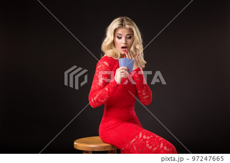 Young woman in casino with cards over black background. Poker 97247665
