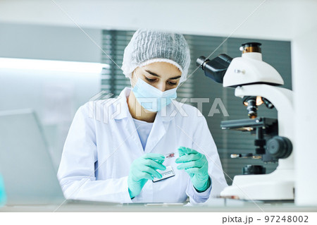 Young woman working in laboratory and doing blood tests 97248002