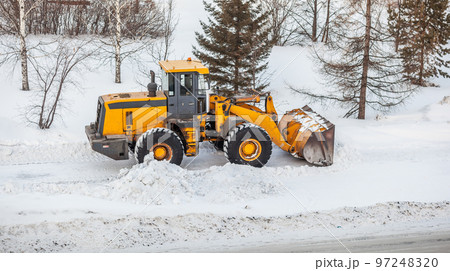 Snow clearing. Tractor clears the way after heavy snowfall. 97248320