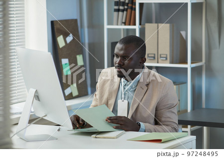 Black businessman using desktop computer in office 97248495