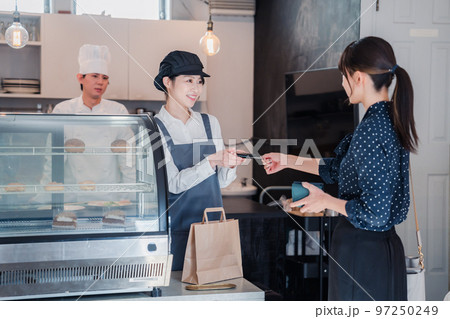 お菓子屋さんでクレジットカード決済をする女性 97250249