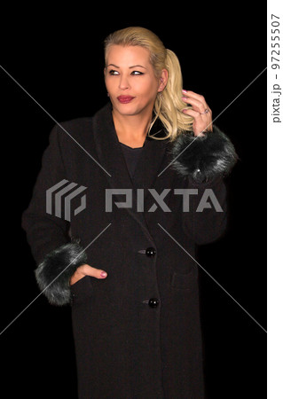 Attractive blonde woman wearing a black cashmere coat Attractive blonde woman wearing a black cashmere coat 97255507