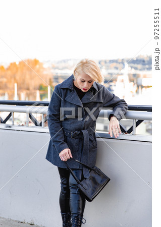 Fashionable blonde woman walking exploring the city. Fashionable blonde woman walking exploring the city. 97255511