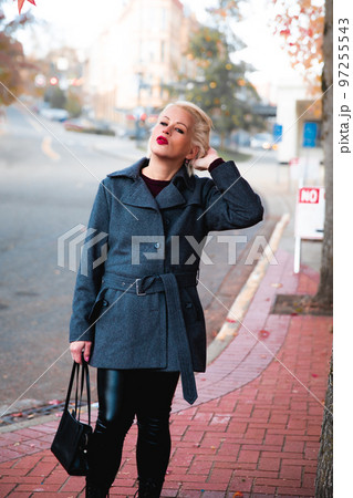 Fashionable blonde woman walking exploring the city. 97255543