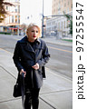 Fashionable blonde woman walking exploring the city. 97255547