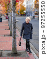 Fashionable blonde woman walking exploring the city. 97255550