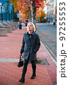 Fashionable blonde woman walking exploring the city. 97255553