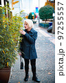 Fashionable blonde woman walking exploring the city. 97255557