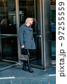 Fashionable blonde woman walking exploring the city. 97255559