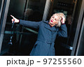 Fashionable blonde woman walking exploring the city. 97255560
