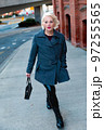 Fashionable blonde woman walking exploring the city. 97255565