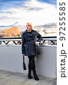 Fashionable blonde woman walking exploring the city. 97255585