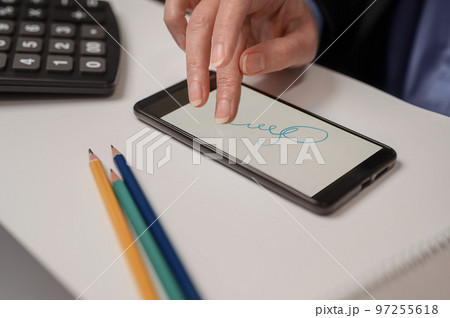 a woman signs a distance contract in a mobile phone. electronic signature concept 97255618