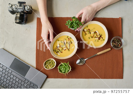 High angle view of young photographer preparing still life, she putting bowls with soup on napkin for shooting 97255757