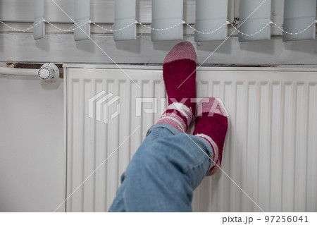 Warming cold feet on a hot radiator. Thick wool socks. 97256041