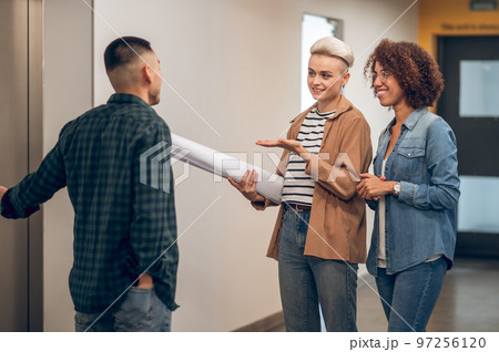 Three company employees waiting together for the elevator Three company employees waiting together for the elevator 97256120