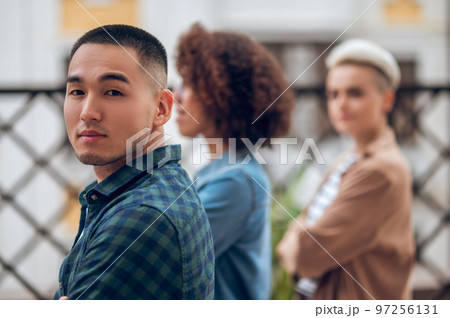 Attractive Asian man accompanied by ladies outdoors 97256131