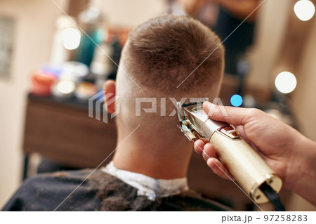 Barber shaving caucasian man in barber shop 97258283
