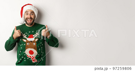Christmas holidays, celebration and party concept. Happy bearded guy in Santa hat showing thumbs up in approval, like something awesome, white background Christmas holidays, celebration and party concept. Happy bearded guy in Santa hat showing thumbs up in approval, like something awesome, white background 97259806
