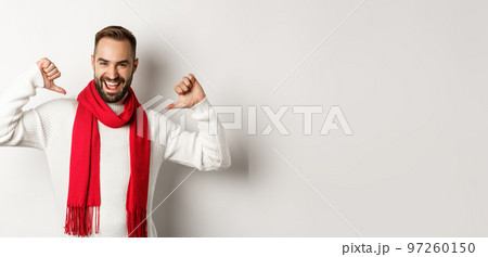 Winter holidays and shopping concept. Confident bearded man pointing at himself and smiling satisfied, celebrating christmas in red scarf and sweater, white background Winter holidays and shopping concept. Confident bearded man pointing at himself and smiling satisfied, celebrating christmas in red scarf and sweater, white background 97260150