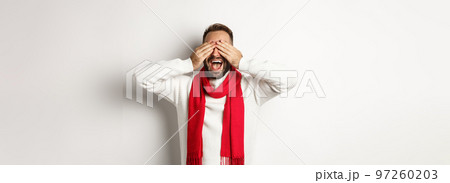 Christmas concept. Happy man close his eyes and waiting for gifts, smiling excited, celebrating new year, winter holidays, standing over white background Christmas concept. Happy man close his eyes and waiting for gifts, smiling excited, celebrating new year, winter holidays, standing over white background 97260203