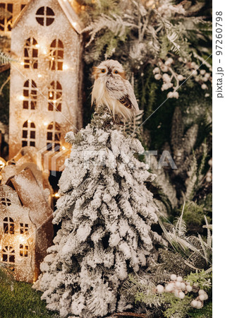 Stuffed owl on a tree with snow lying on its Stuffed owl on a tree with snow lying on its 97260798