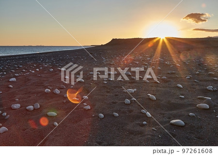 Iceland landscape black sand beach with stones and sunset flare Iceland landscape black sand beach with stones and sunset flare 97261608