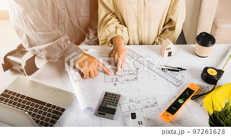 Two engineers pointing at drawings project, Architect team meeting consult and work for architectural construction project working with partner and engineering after editing on blueprint paper plans Two engineers pointing at drawings project, Architect team meeting consult and work for architectural construction project working with partner and engineering after editing on blueprint paper plans 97261628